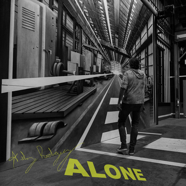 Alone single cover art by Anthony Rodriguez: a man walking down a black-and-white industrial corridor with “ALONE” in yellow-green letters