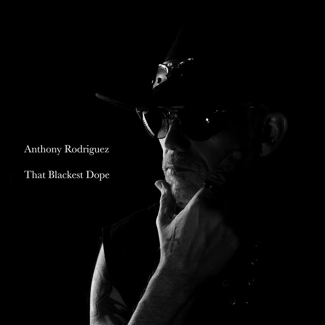 That Blackest Dope single cover art: black-and-white low-key portrait of Anthony Rodriguez in a hat and sunglasses